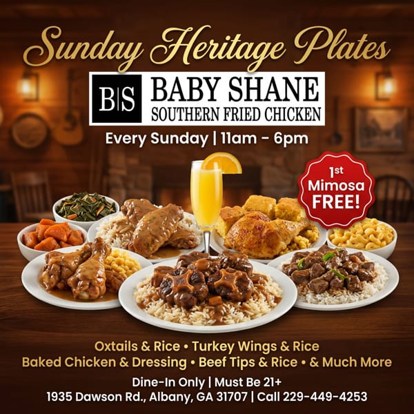 A spread of Southern dishes including oxtails, turkey wings, baked chicken, and beef tips with rice, plus sides and a mimosa.