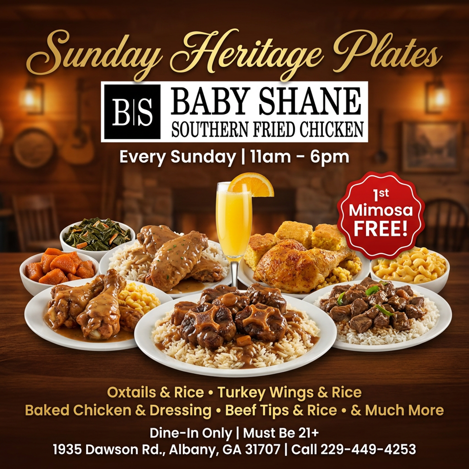 A spread of Southern dishes including oxtails, turkey wings, baked chicken, and beef tips with rice, plus sides and a mimosa.